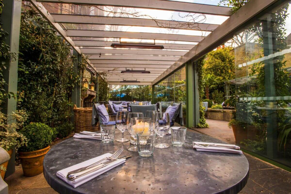 Bromic Tungsten patio heaters at in-glassed garden restaurant terrace